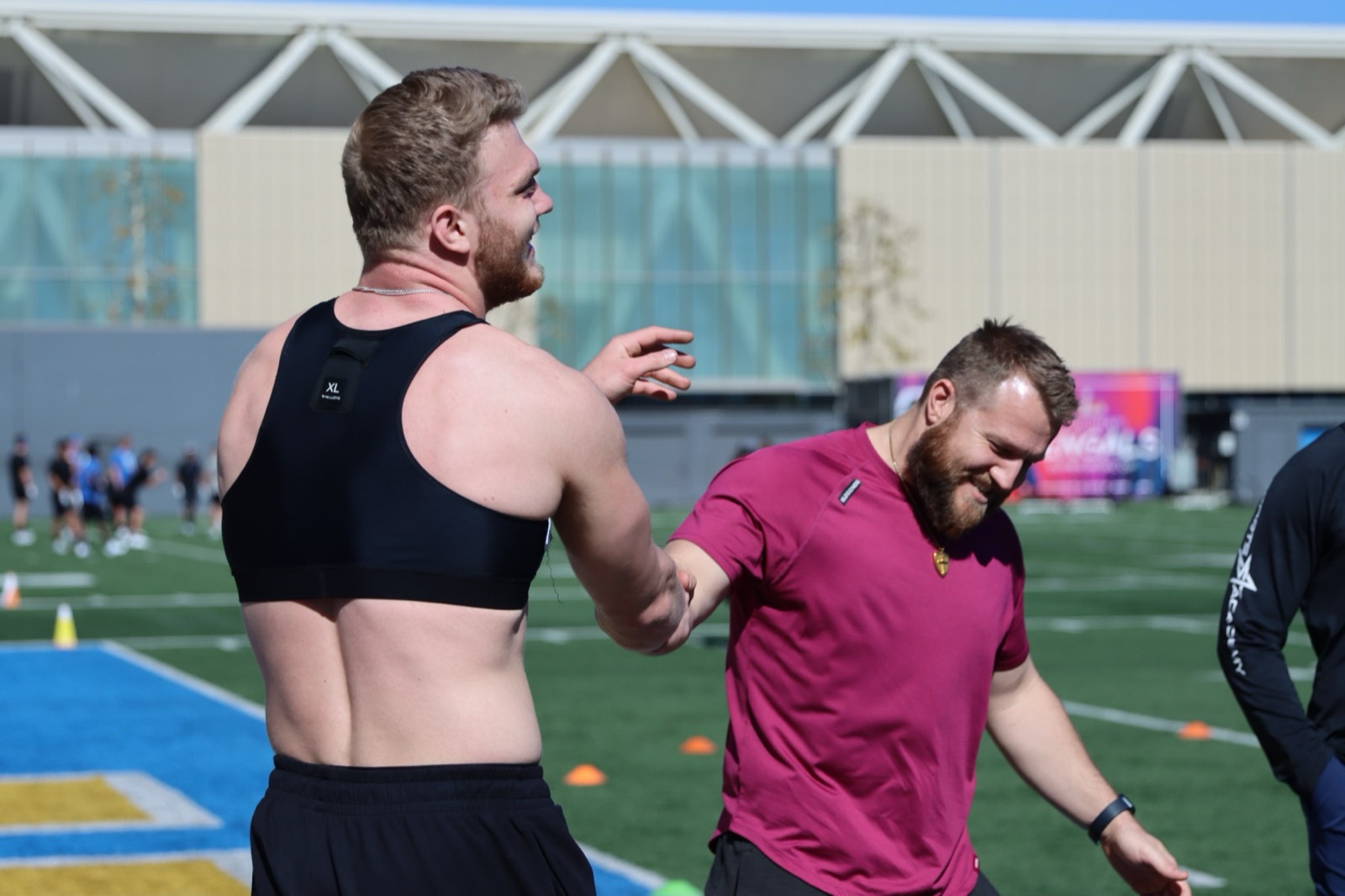 Coach Taylor Ramsey with an athlete on the training field